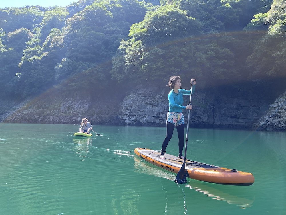 渓谷の湖でSUPをする人たち